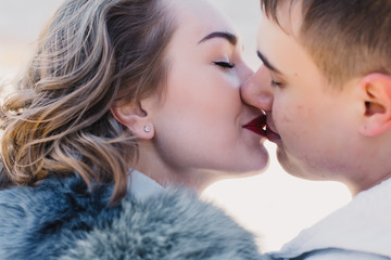 Happy couple in love hugging and sharing emotions, holding hands on a bench by the river