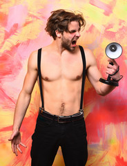 Fototapeta na wymiar Caucasian bearded macho man in pants with suspenders holding lamp