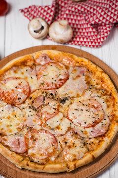 Hot true ITALIAN PIZZA with salami and cheese. TOP VIEW Tasty traditional pepperoni pizza on board on white wooden table with decoration. Copy space for your logo. Ideal for commercial
