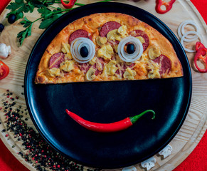 Large hot pizza on the black plate.
