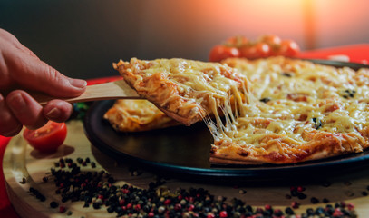 A slice of pizza in his hand. A restaurant.