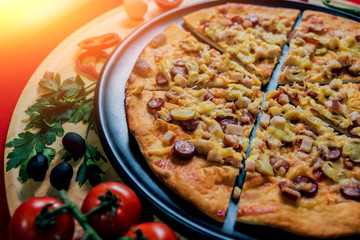 Large hot pizza on the black plate.