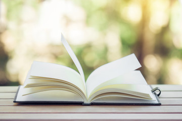 Open book on wood planks background.