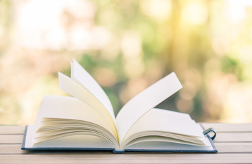 Open book on wood planks background