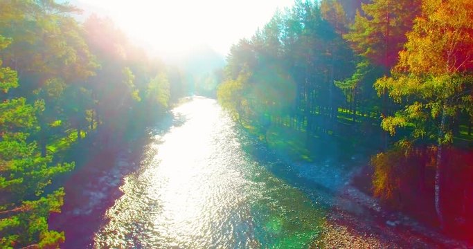 Aerial UHD 4K view. Mid-air flight over fresh mountain river at sunny summer morning. Vertical to horizontal tilt movement.