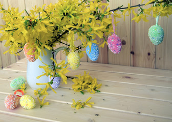 Easter color eggs are a holiday symbol. Eggs are located on branches of the blossoming forzition. Decorative bouquet.