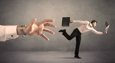 Businessman running from hand