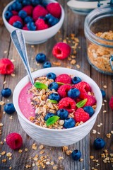 Breakfast smoothie bowl  with granola, fresh raspberry, blueberry, chia seeds and mint