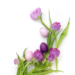 Easter eggs and tulips on white background. Flat lay. Top view