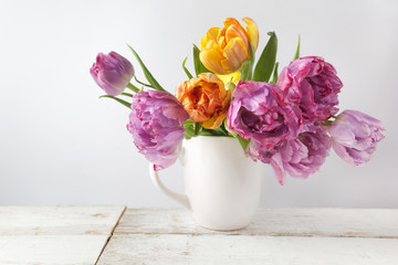 Fresh bouquet of tulips in pot on rustic wood. Vintage stile