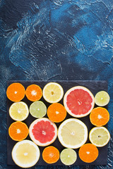 Cut citrus fruits on the dark blue background