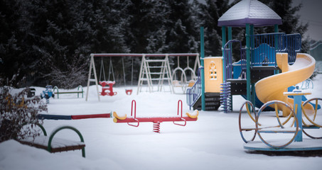 Children's Playground with swings and a slide in the snow