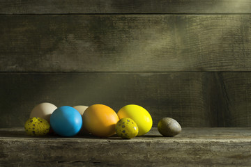 Easter still life with colorful eggs on an old wooden background