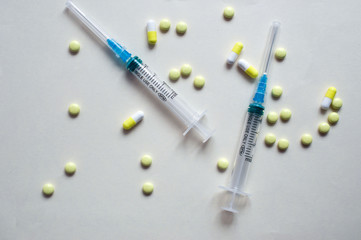 White and yellow capsules and syringes
