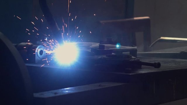 CU shot of robot arm welding car part on a factory. Industrial process, no people. 4K UHD 60 FPS