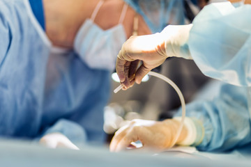 Surgeon wearing gloves operates women's breasts . Operation close up.