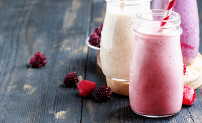 Selection of pink berry smoothies and milkshakes, gray background, selective focus