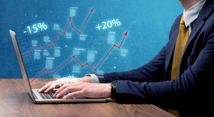 Salesman working on graph with laptop