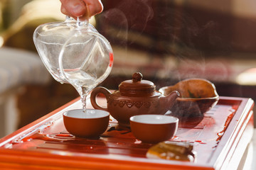 The tea ceremony. Woman pours tea in a tea bowl.