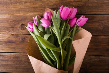 Pink tulips in a package of craft on the wooden background. Pink tulip. Tulips. Flowers. Flower background. Flowers photo concept. Holidays photo concept. Copyspace