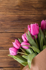 Pink tulips in a package of craft on the wooden background. Pink tulip. Tulips. Flowers. Flower background. Flowers photo concept. Holidays photo concept. Copyspace