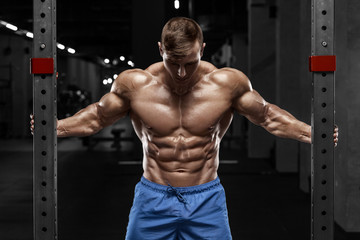 Sexy muscular man in gym, shaped abdominal. Strong male naked torso abs, working out