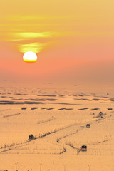 siluate fisherman's wooden hut on sea water with sunset
