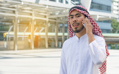 Arab businessman messaging on a mobile phone in the city
