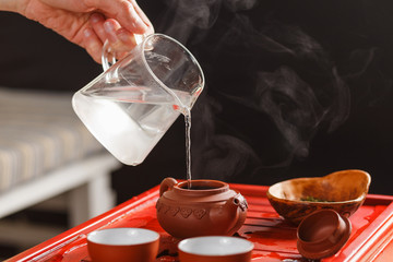 The tea ceremony. The woman pours hot water into the teapot