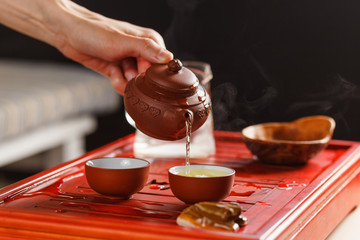 The tea ceremony. Woman pours tea in a tea bowl.