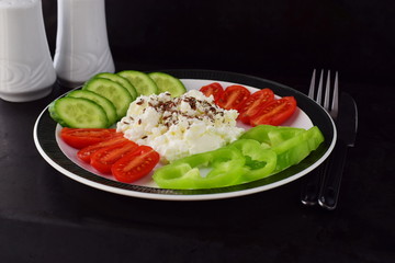 Easy breakfast with paprika, tomato, cucumber with cottage cheese and flax seeds on a plate on a dark background Healthy eating concept. Healthy food