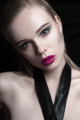 Fototapeta na wymiar Portrait of beautiful girl model with pink lips and blue eyes with leather belt on her neck, fresh clean highlighted skin. Fashion retouched close up shot.