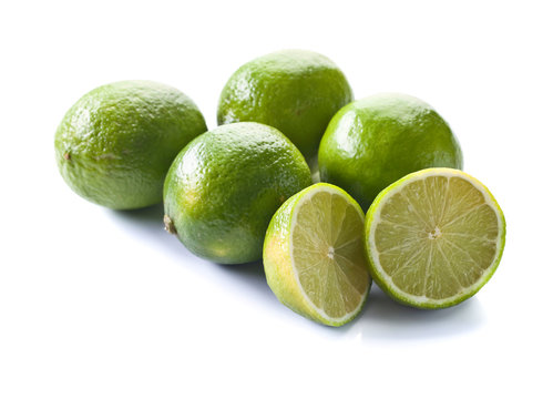 Group of whole and cut fresh limes over white background