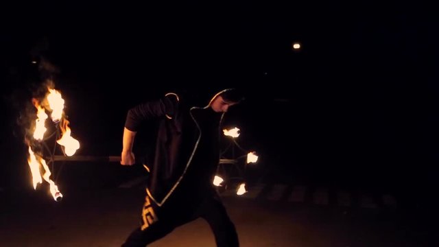 Stick man juggles with fire. Fire Show. Slow motion.