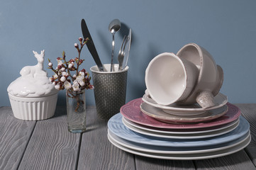 Minimalistic still life: set of rustic white wooden tableware on blue background. Soft light, high...