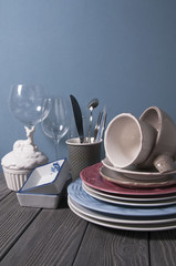 Minimalistic still life: set of rustic white wooden tableware on blue background. Soft light, high key.