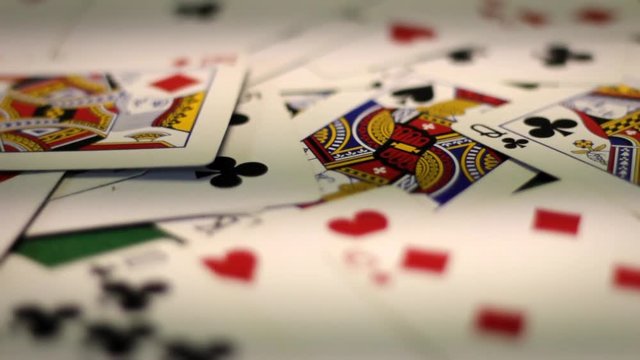 Various designs of poker playing cards on old poker table