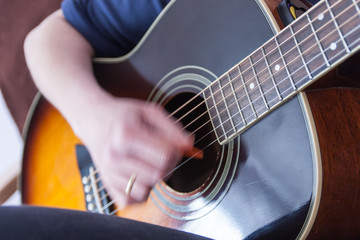 Obraz premium hand playing on an acoustic guitar