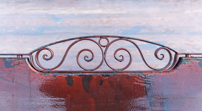 Openwork backrest garden benches on the background of a frozen lake
