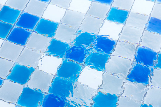 blue ripped water in swimming pool of the hotel. background of water refrection and swimming pool tiles.