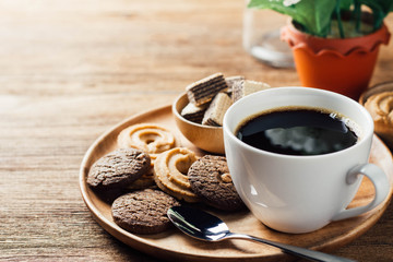 black coffee in white cup with cookie and dessert