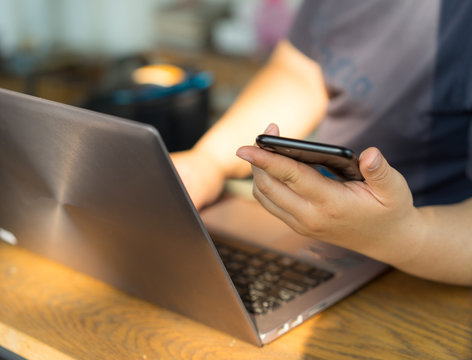Woman hands work on labtop and smart phone.