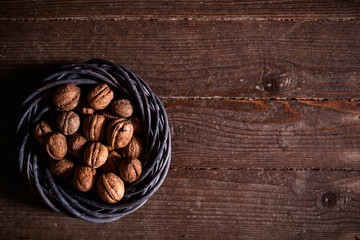 Whole walnuts on rustic old wooden floor, shot in natural light. Concept of healthy organic food.