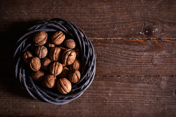 Whole walnuts on rustic old wooden floor, shot in natural light. Concept of healthy organic food.