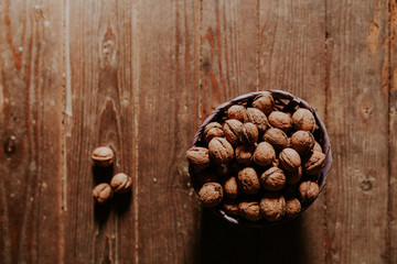Whole walnuts on rustic old wooden floor, shot in natural light. Concept of healthy organic food.