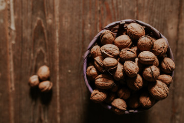 Whole walnuts on rustic old wooden floor, shot in natural light. Concept of healthy organic food.