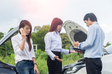 Obraz premium Car collision. Asian driver man and woman examining damaged automobile cars after crash accident in city