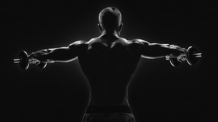 Black and white image of dumbbell lateral raise routine Bodybuilder turning back raising hands...