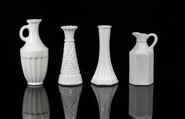 four elegant white vases on black background