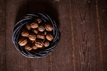 Whole walnuts on rustic old wooden floor, shot in natural light. Concept of healthy organic food.